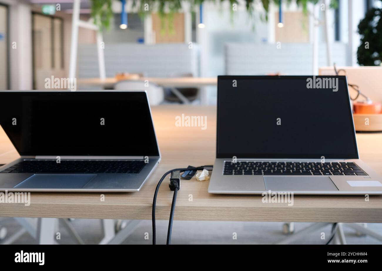 Laptops on a table in an empty co-working space Stock Photo