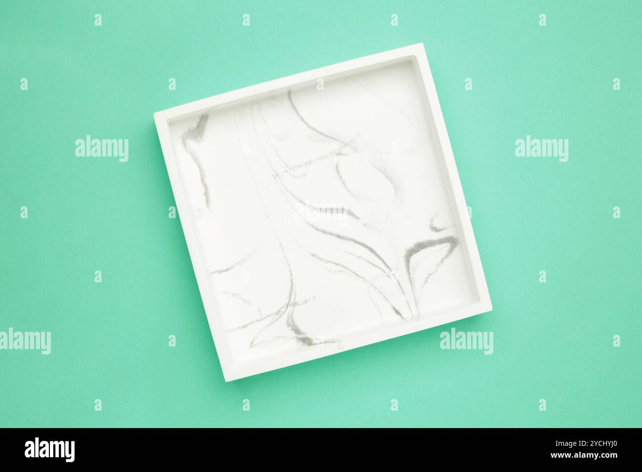 Ceramic square tray on a mint background. Top view Stock Photo