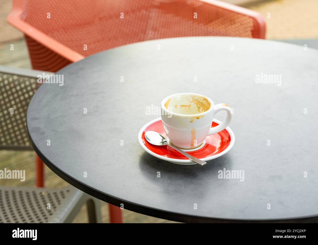 Lonely empty coffee cup with a spoon on a cafe table, finished coffee concept Stock Photo