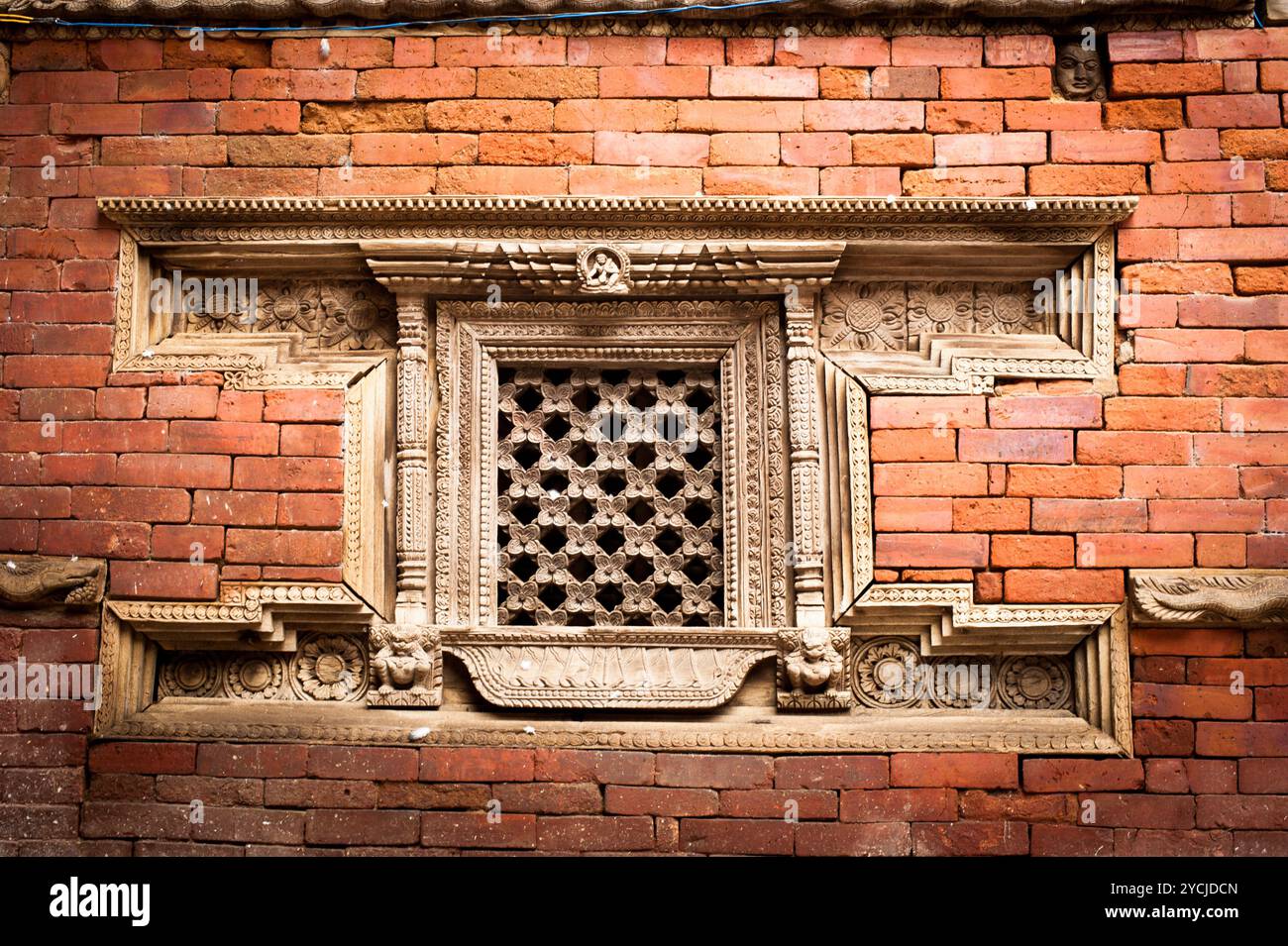 Hindu temple architecture detail. Carved wooden window on old Royal Palace. Nepal Stock Photo