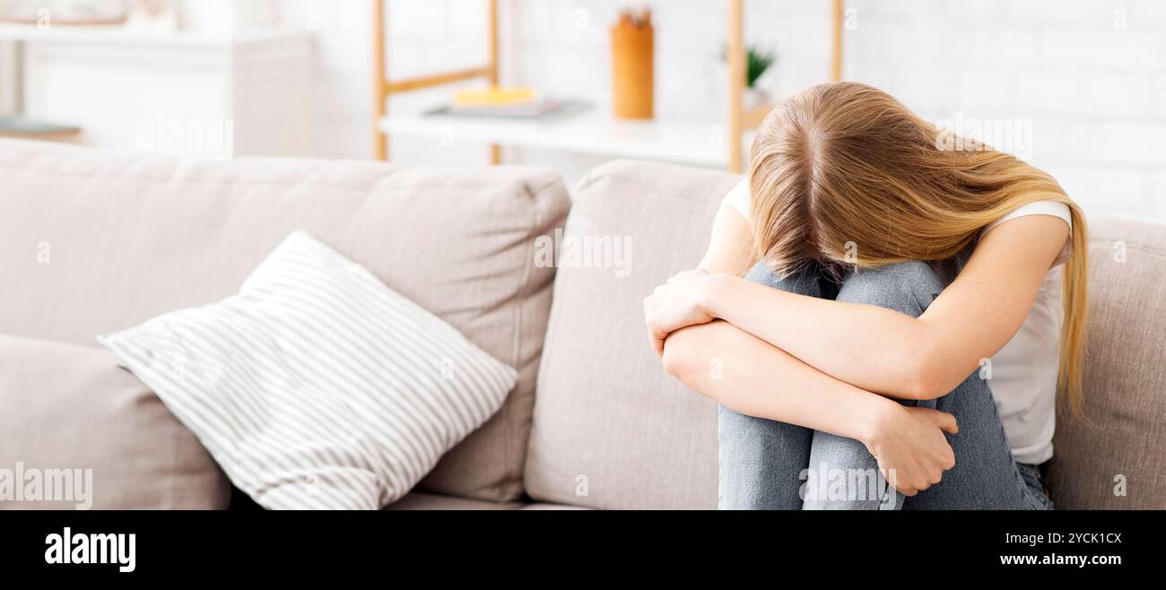 Hopeless girl sitting on couch and crying Stock Photo - Alamy