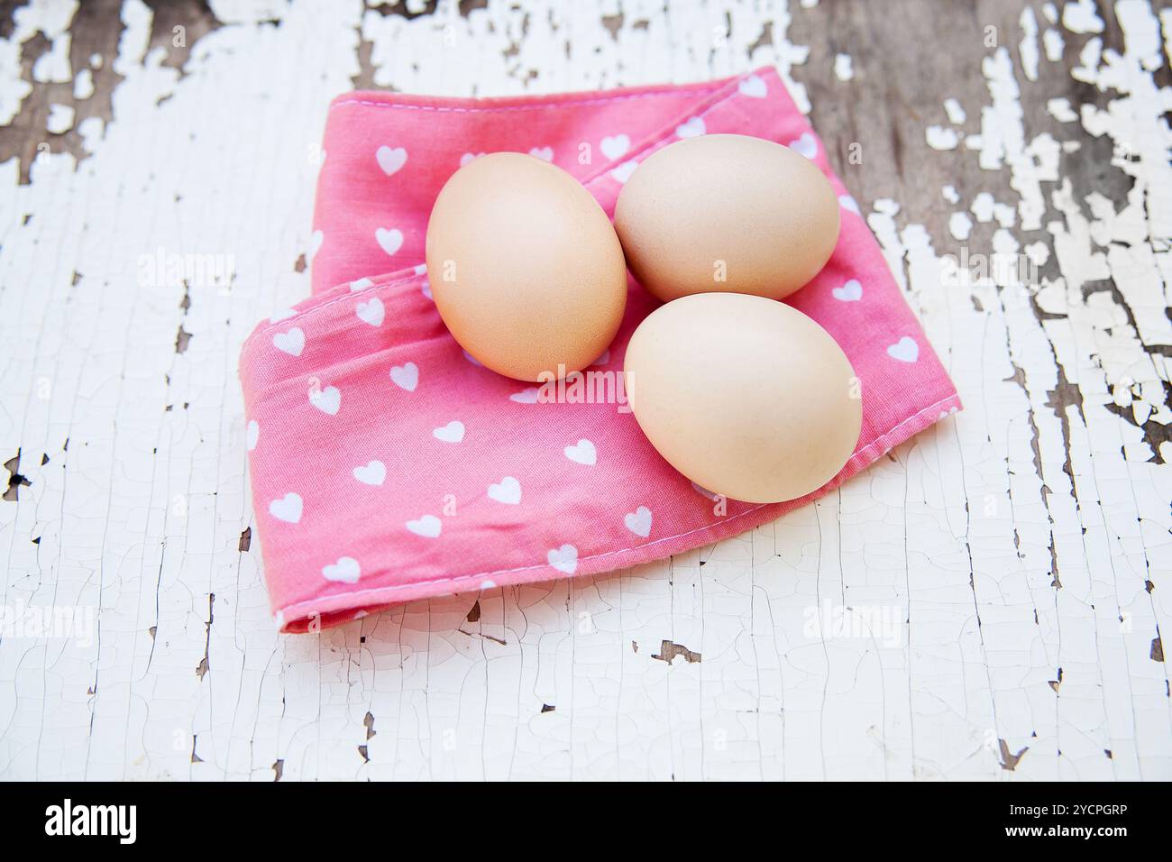 Eggs on tablecloth over wooden background Stock Photo