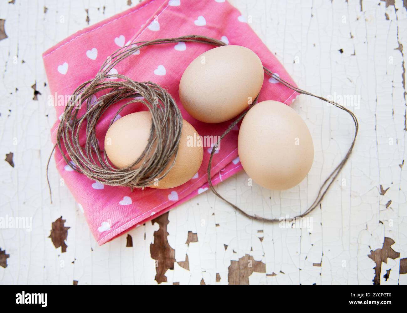 Eggs on tablecloth over wooden background Stock Photo