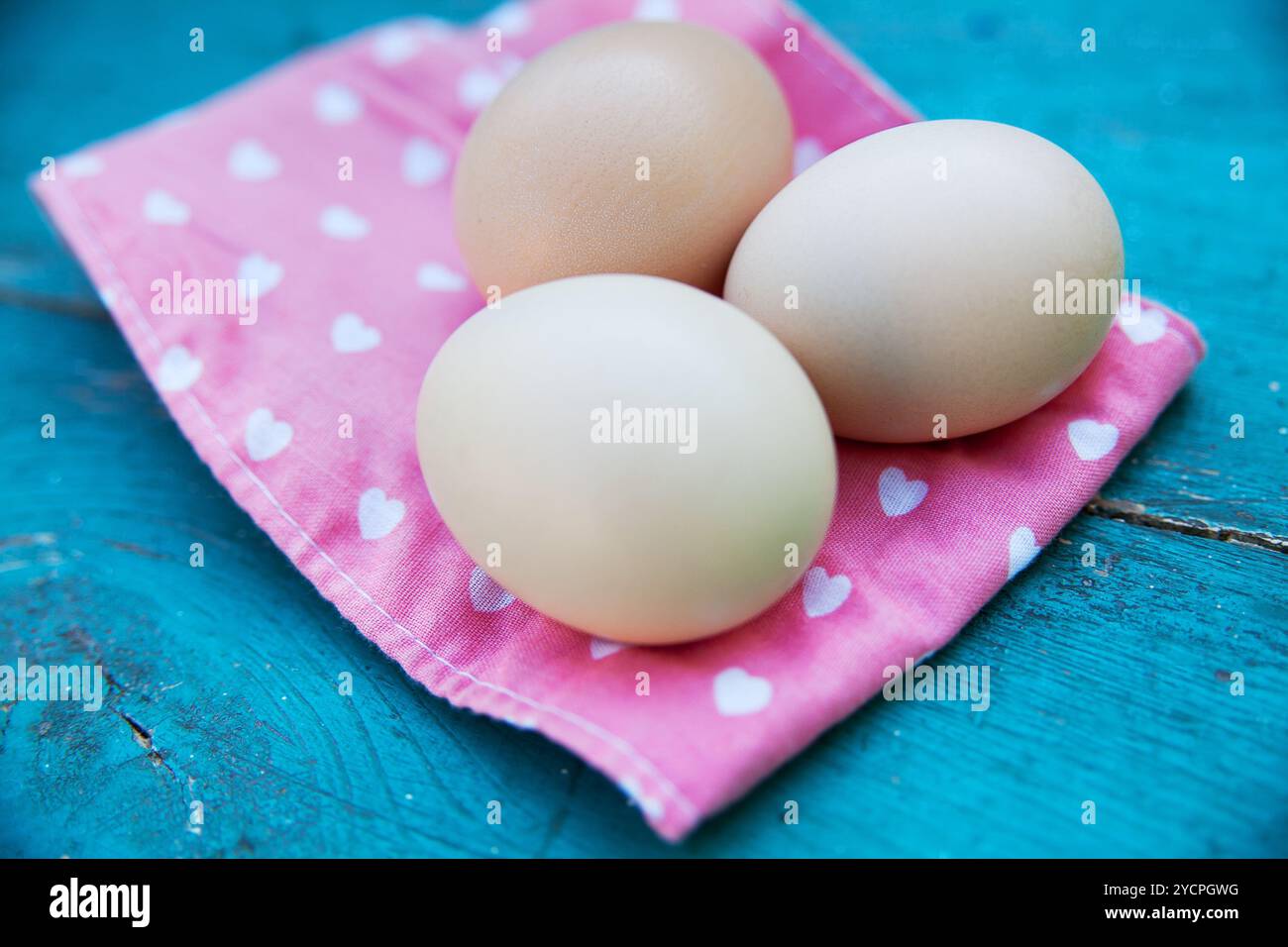 Eggs on tablecloth over wooden background Stock Photo