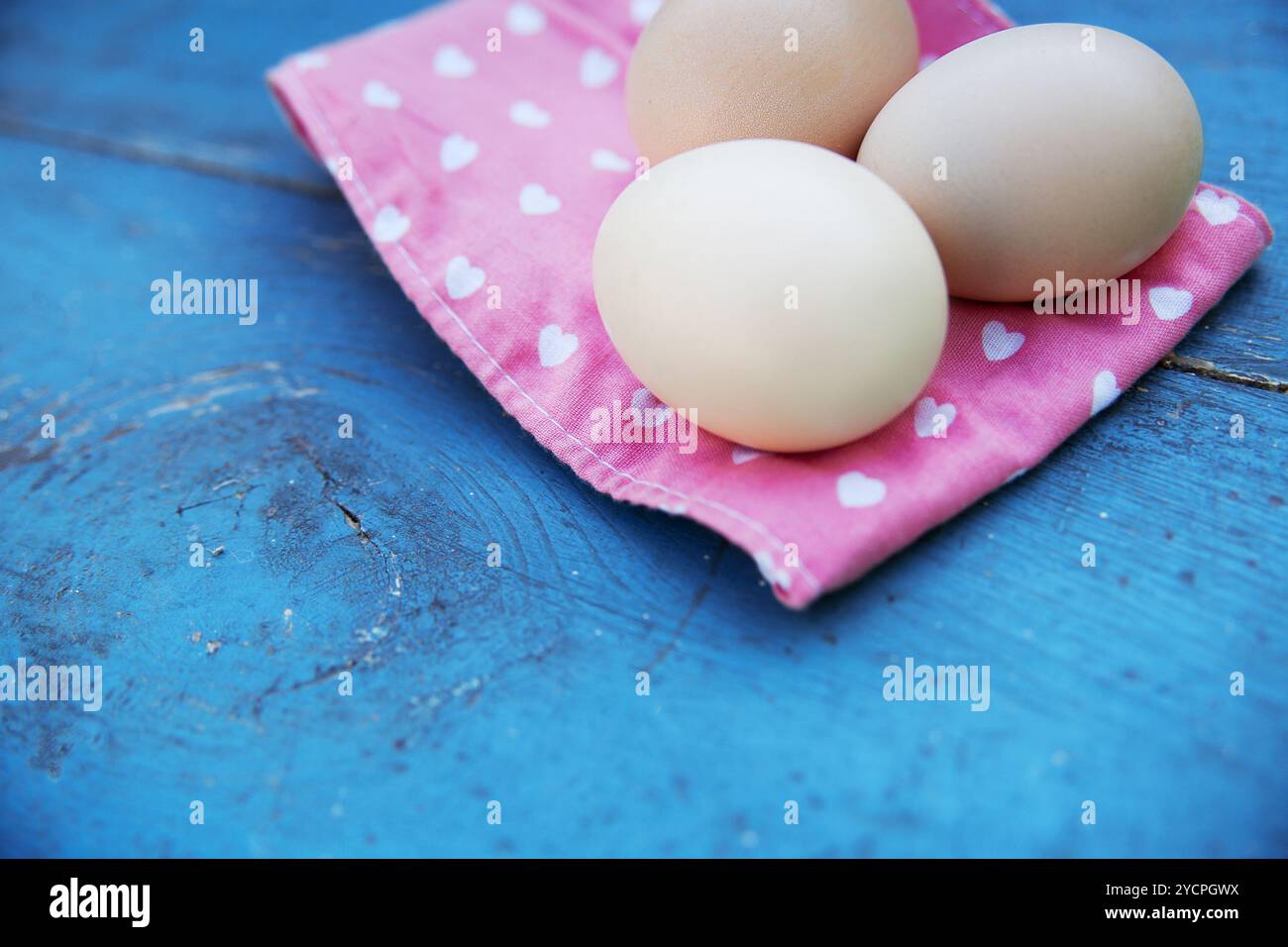 Eggs on tablecloth over wooden background Stock Photo
