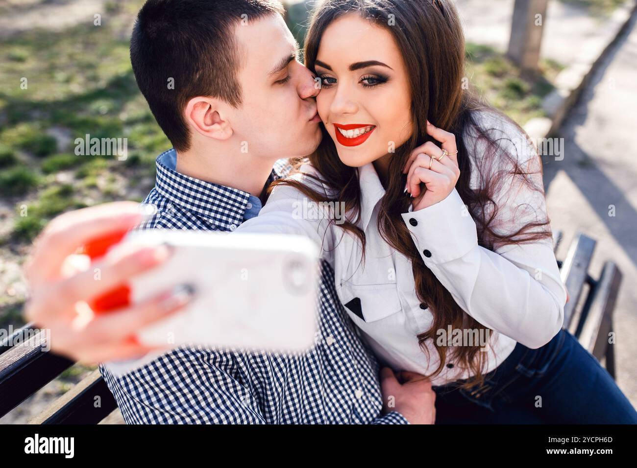 beautiful young couple having fun on a bench in the park Stock Photo ...