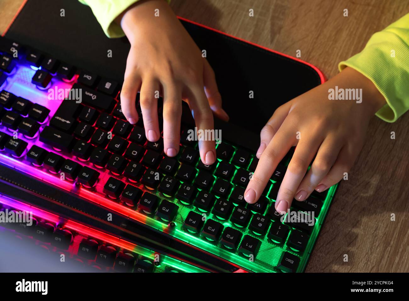 Girl using computer keyboard at wooden table, top view Stock Photo - Alamy