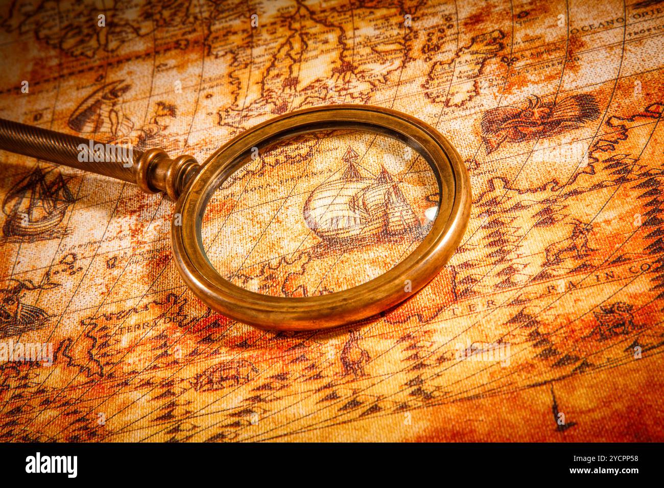 Vintage magnifying glass lies on an ancient world map Stock Photo - Alamy