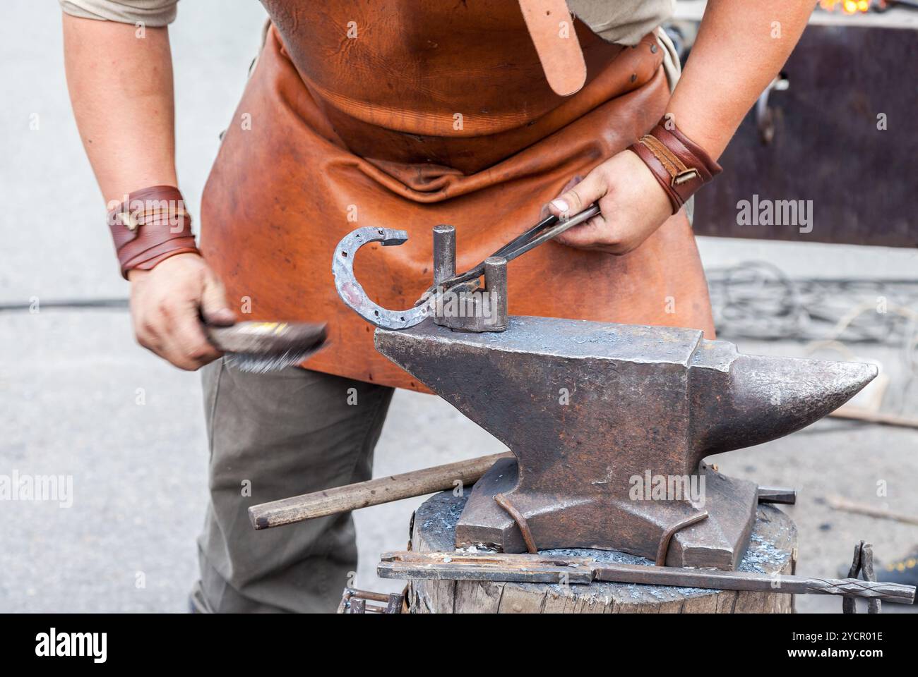 Blacksmith handles the horseshoe on the anvil Stock Photo