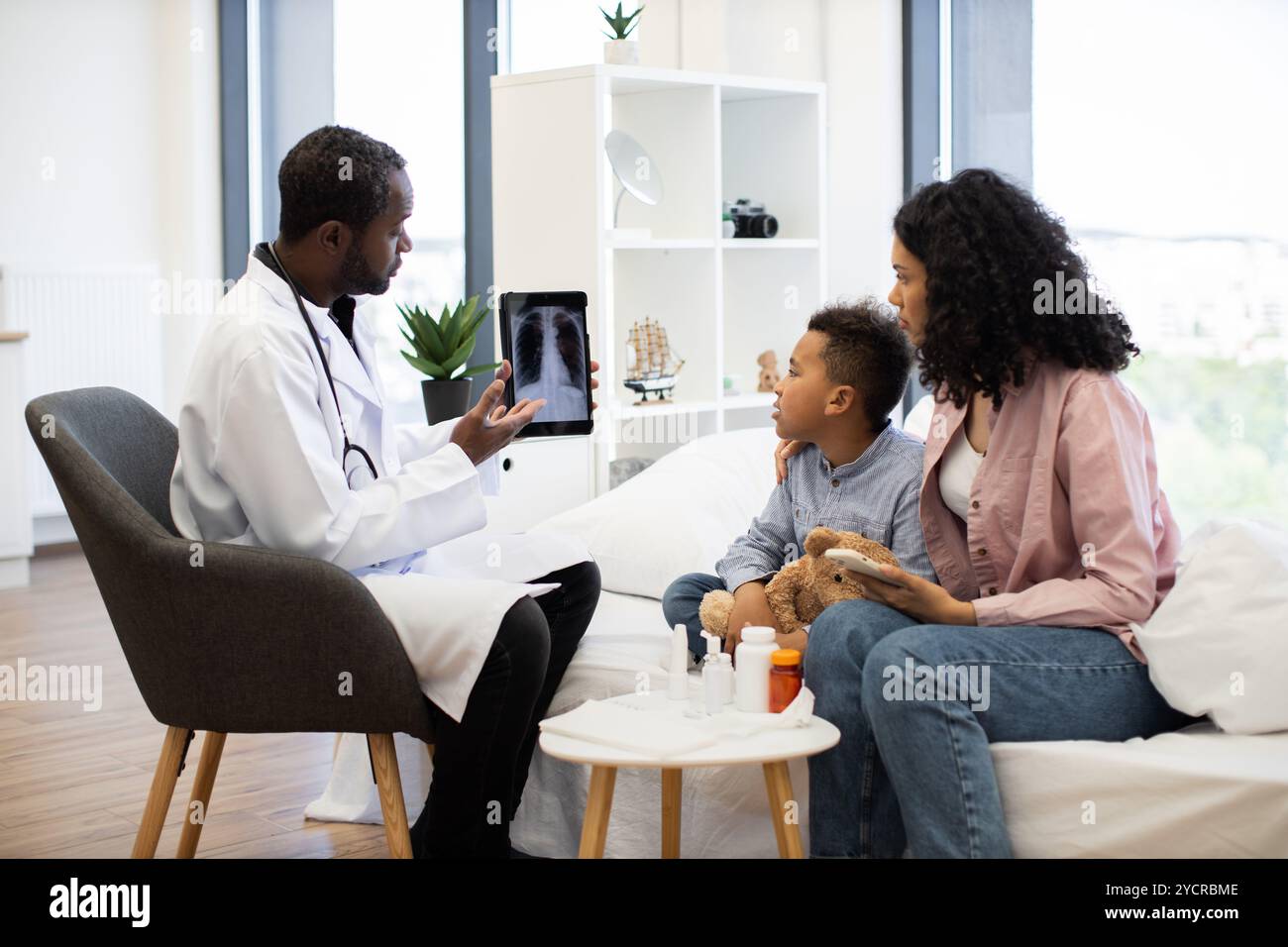 Doctor showing x-ray to mother and son in cozy office Stock Photo - Alamy