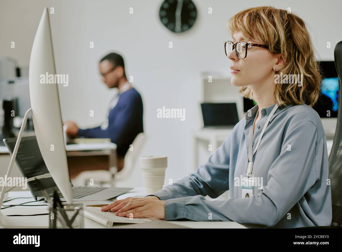 Young Woman Working On Desktop Computer In Office Stock Photo