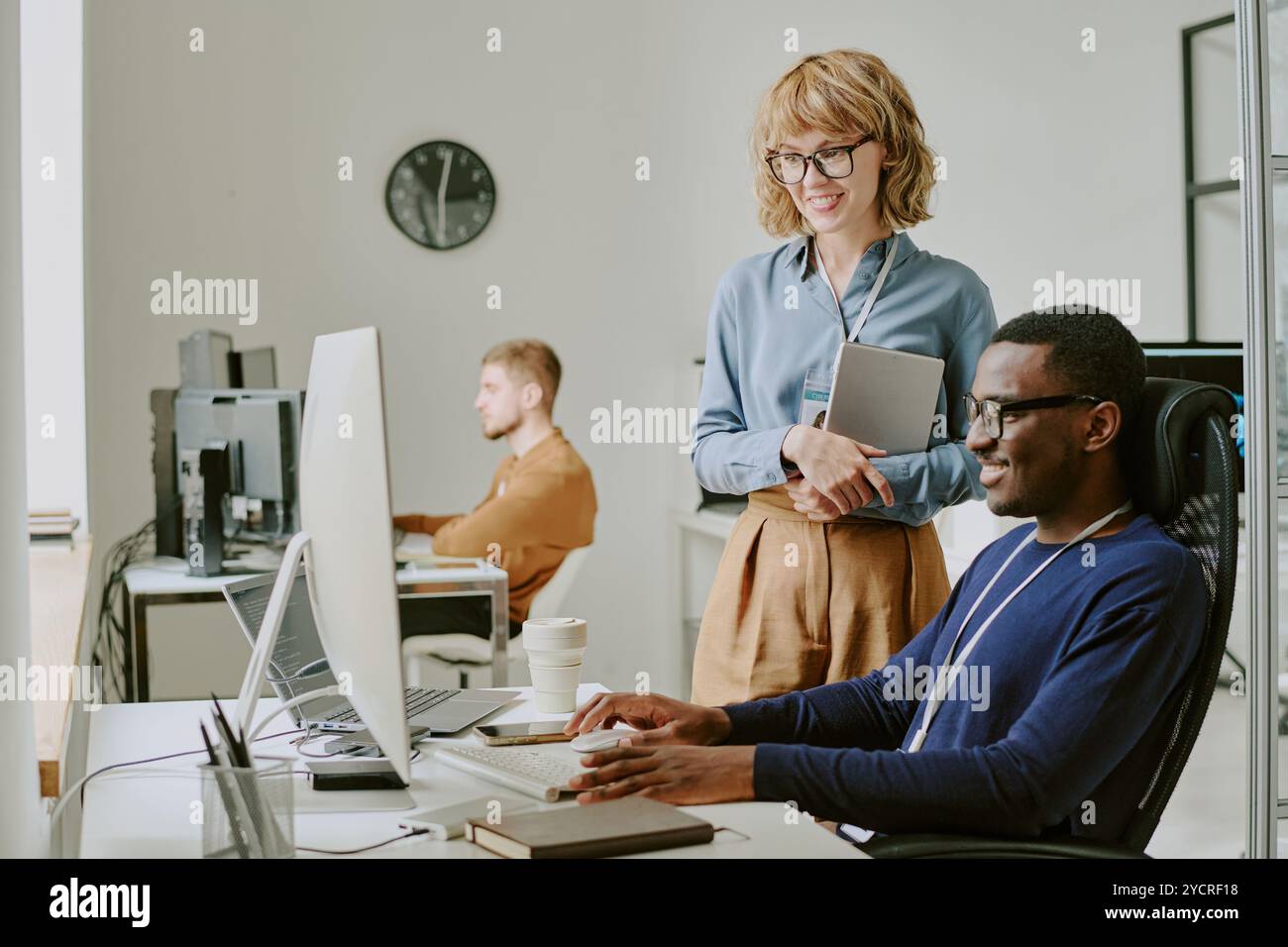IT Specialists Smiling While Looking At Computer Screen Stock Photo