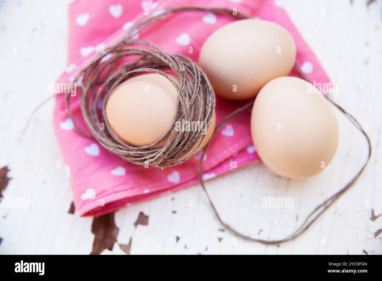 Three eggs on the table with a rose napkin Stock Photo