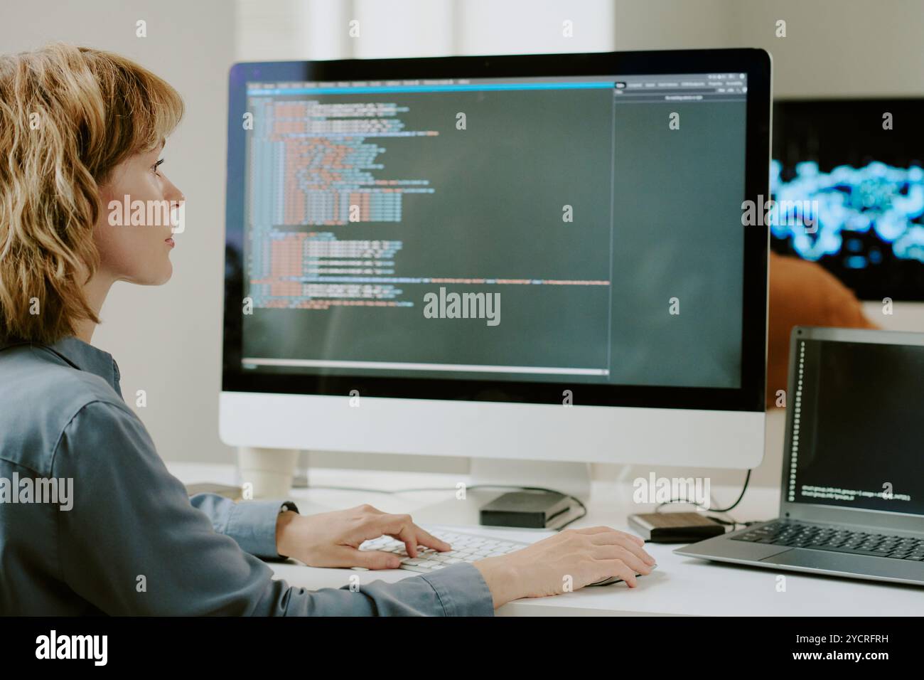 Female Developer Coding On Desktop Computer Stock Photo