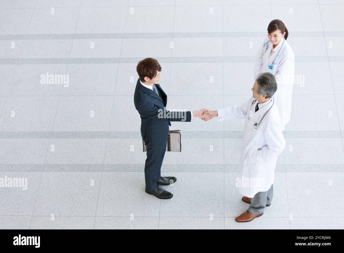 Businessman and doctor shaking hands Stock Photo