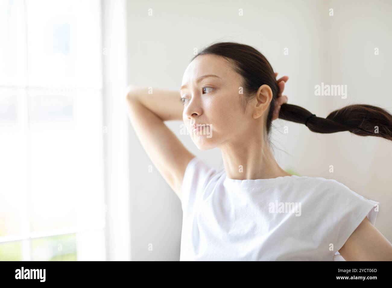 Woman putting her hair up Stock Photo - Alamy
