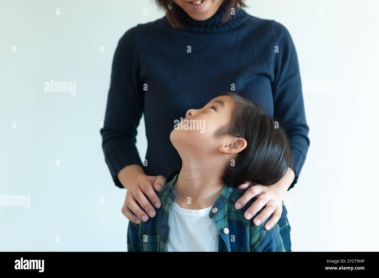 Girl looking up at her mother Stock Photo