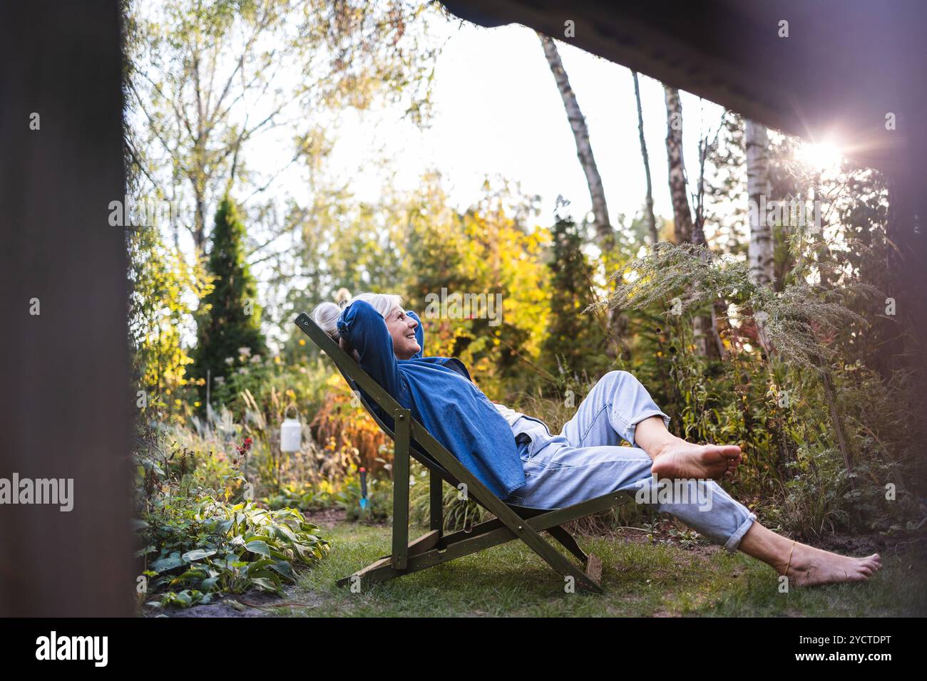Mature woman relaxing in deckchair in her garden Stock Photo - Alamy