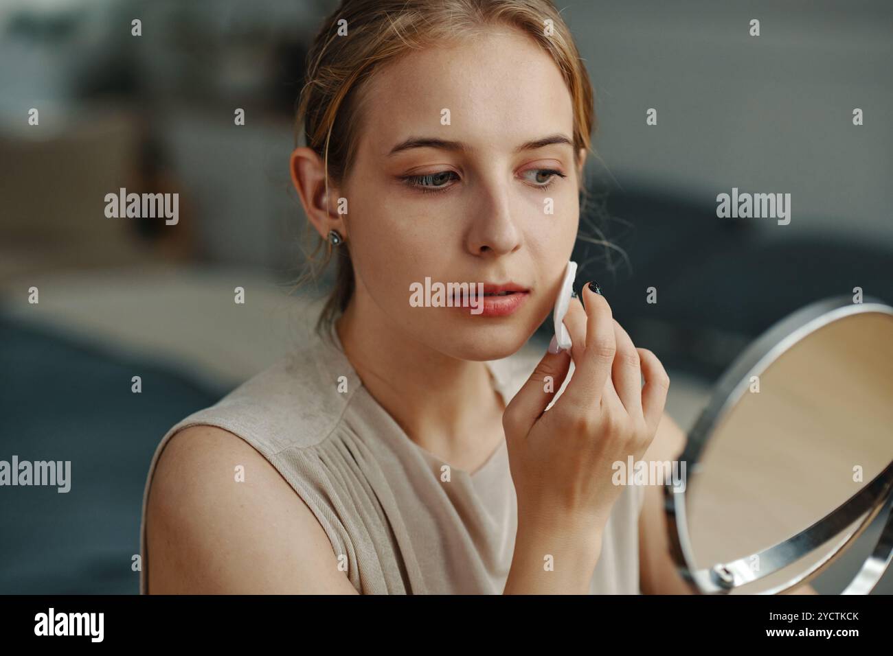 Applying Makeup in Front of a Handheld Mirror Stock Photo