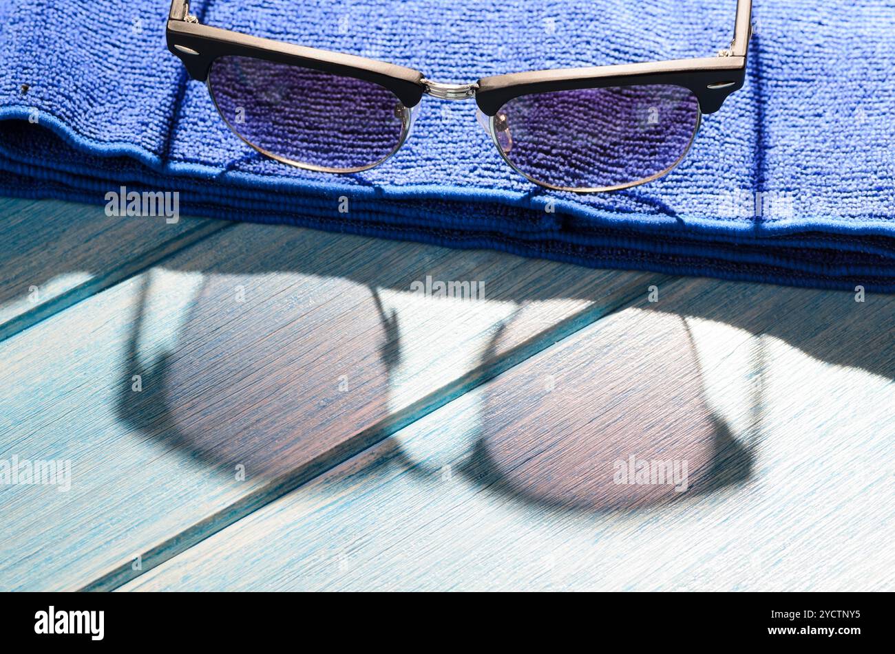 Stylish sunglasses and towel on table Stock Photo