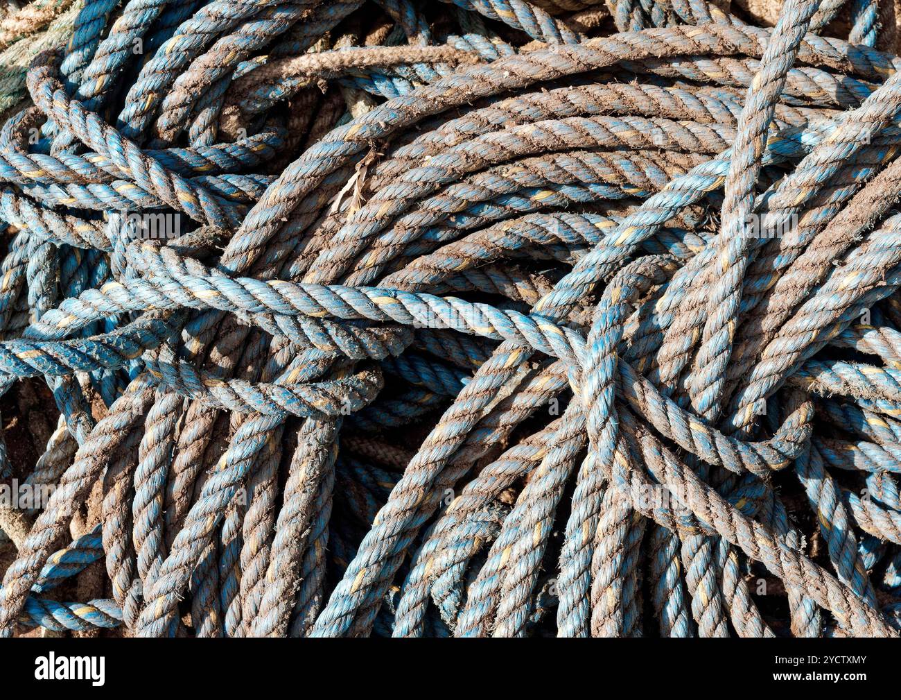 Stacks of coiled and weathered ropes stored on the quayside of the Yorkshire fishing port of Bridlington. Stock Photo