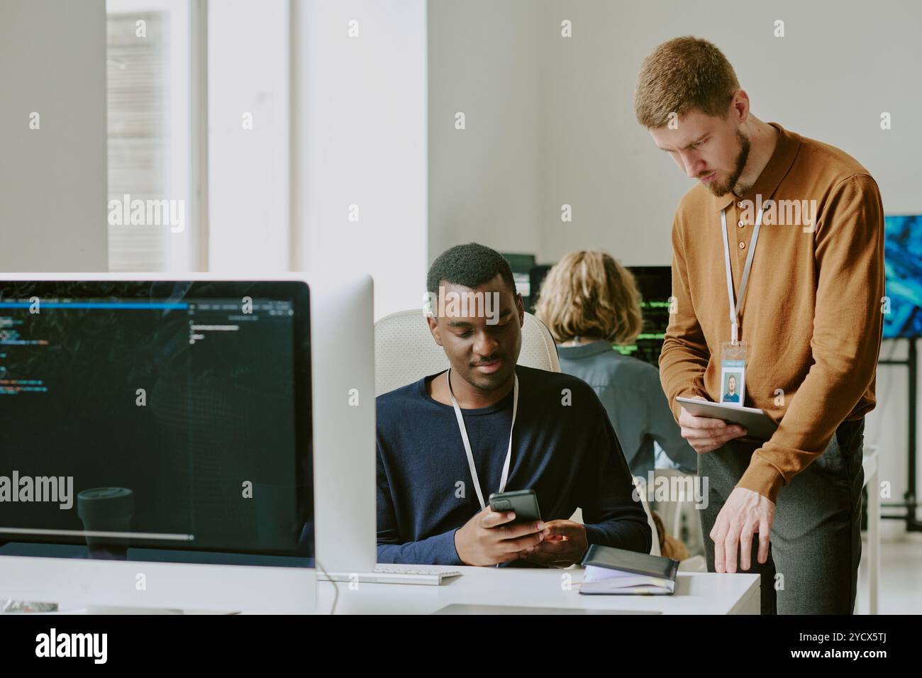 Young Specialists Checking Data Using Gadgets Stock Photo