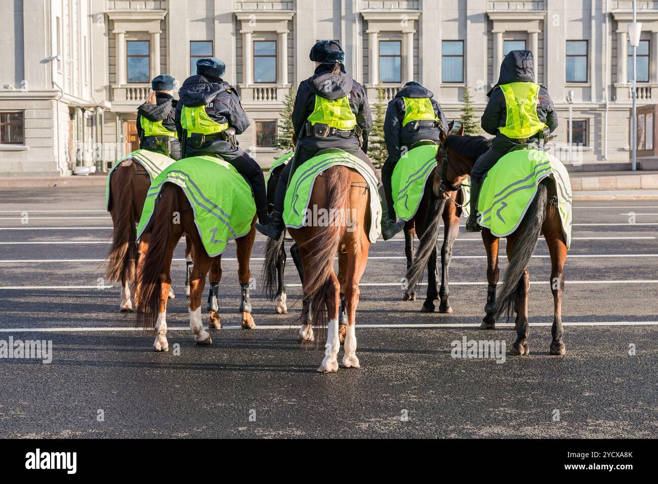 Female mounted police on horse back at the city street Stock Photo