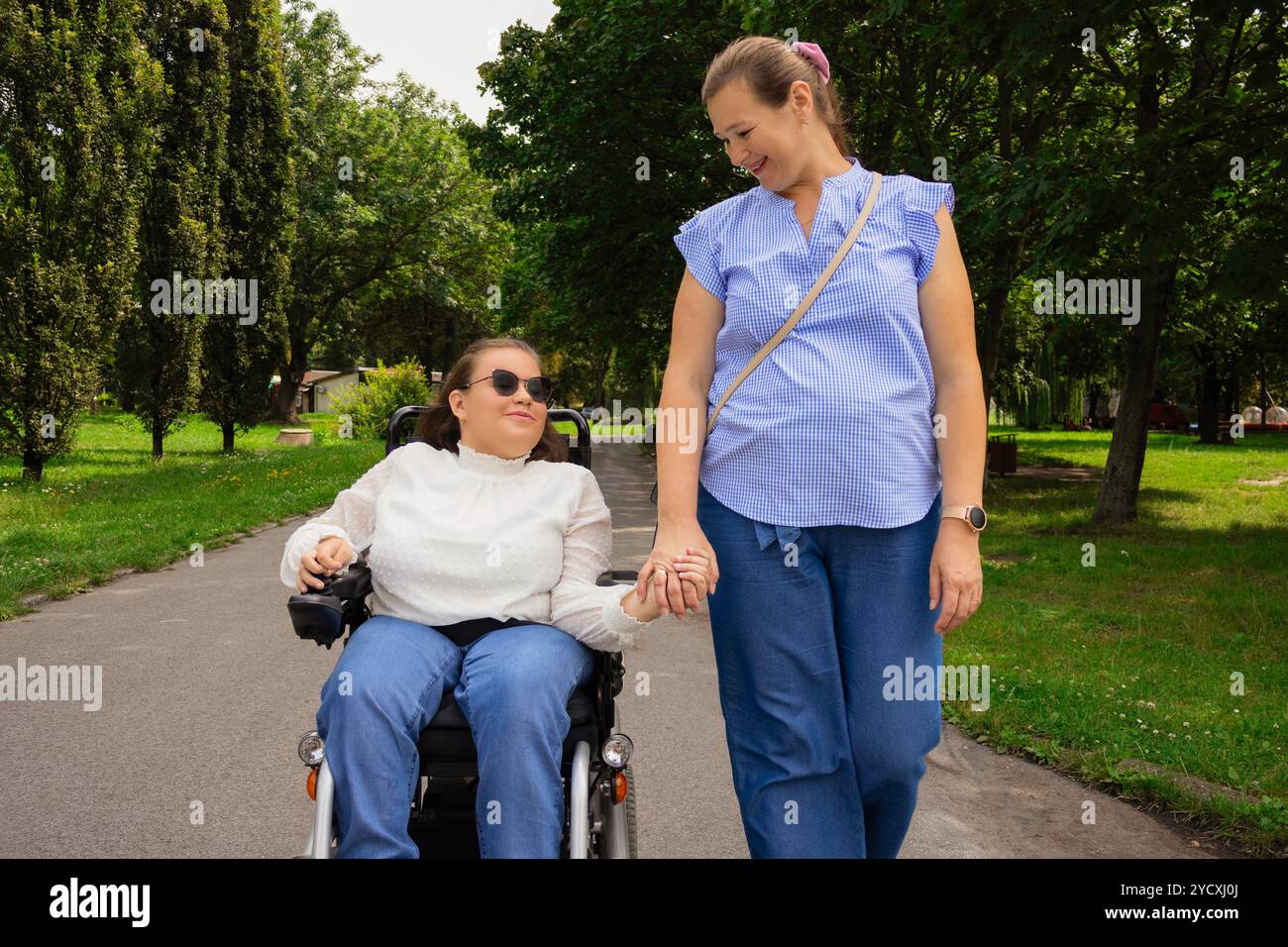A heartfelt moment as a young girl in a wheelchair shares a walk with ...