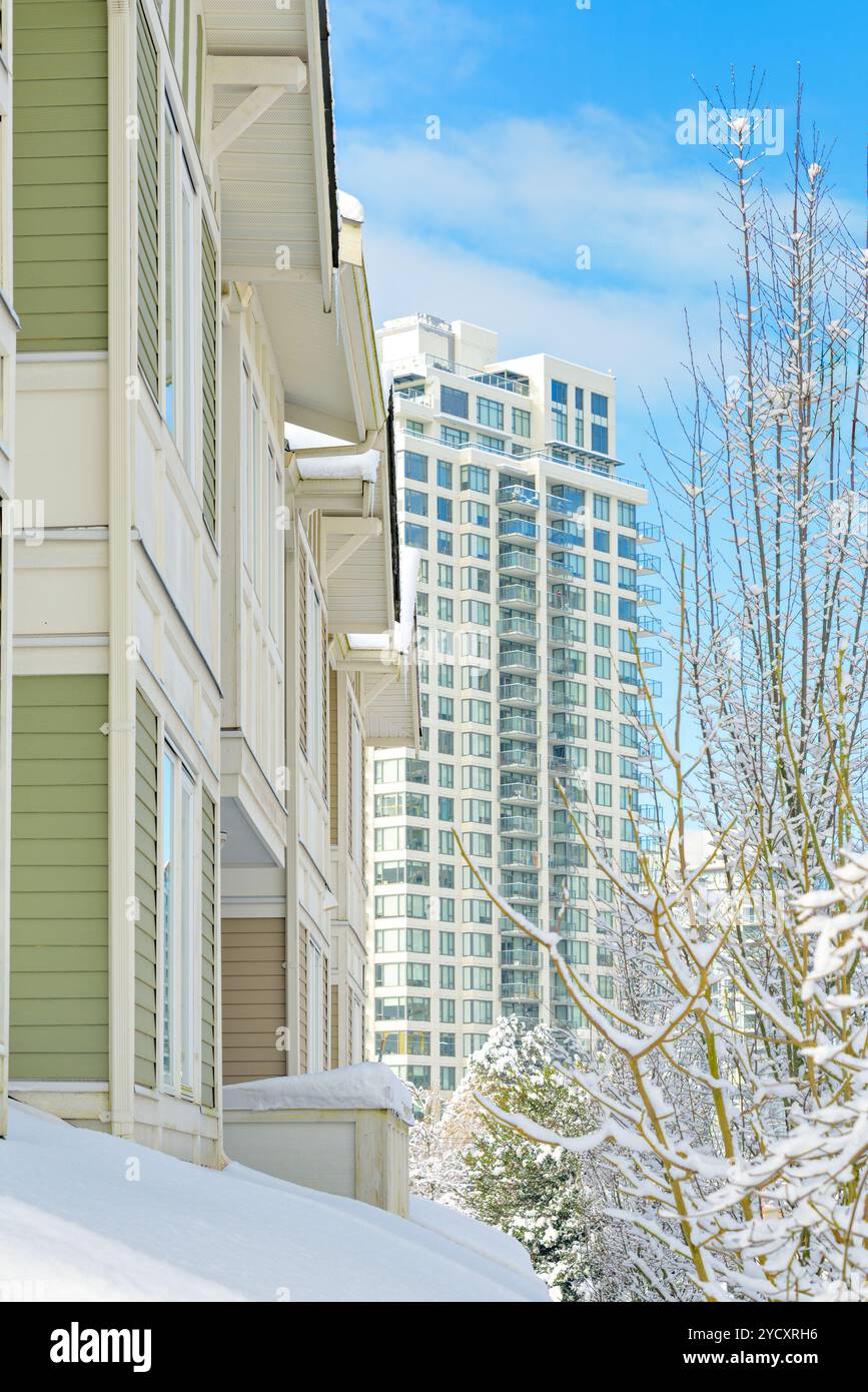 Residential townhouses and high-rise building on bright winter day ...