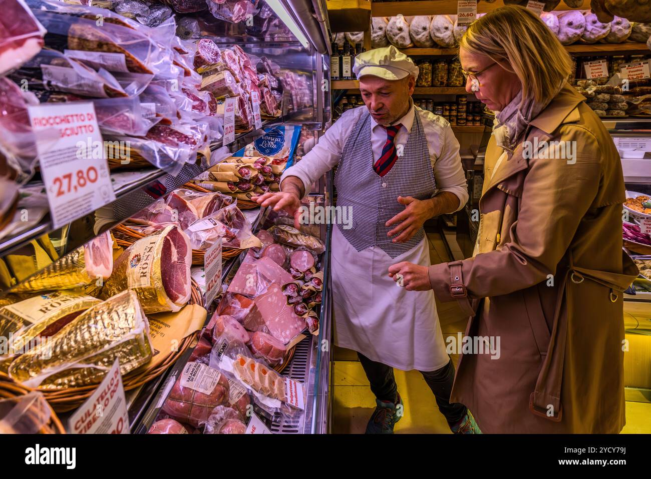 Consultation in a delicatessen for sausage products. Via Drapperie, Bologna, Emilia-Romagna, Italy Stock Photo