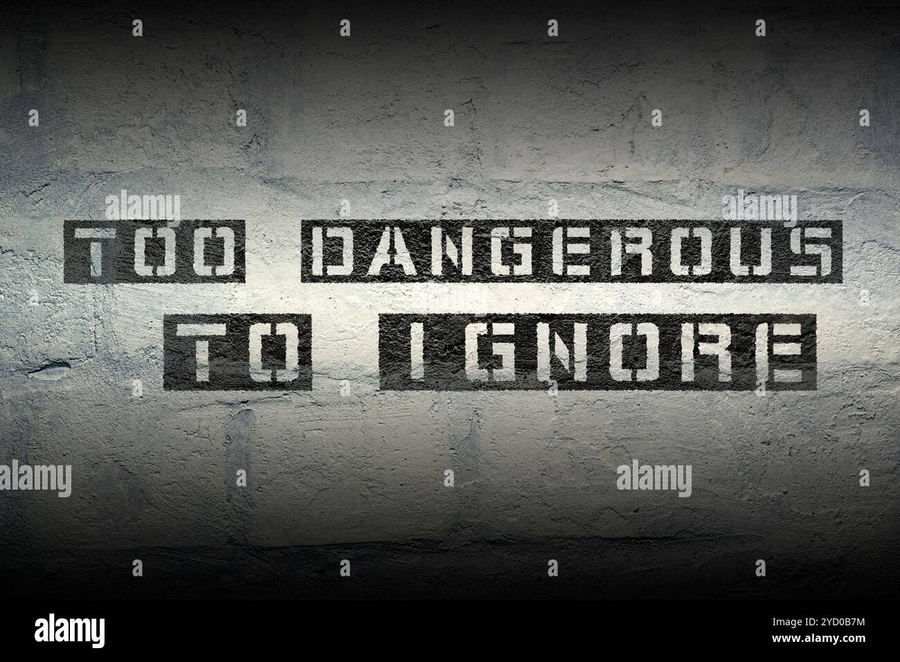 too dangerous to ignore stencil print on the grunge white brick wall