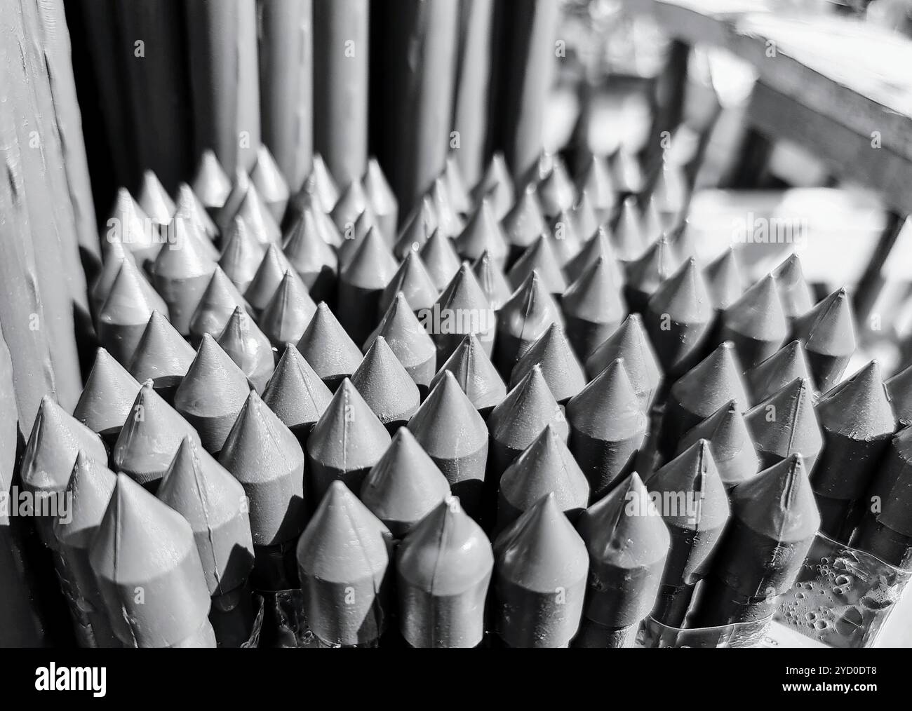 A cluster of tiny, pointed stakes line up, reminiscent of a miniature defense against creeping horrors on a dark Halloween night - Smartphone Captured Stock Image