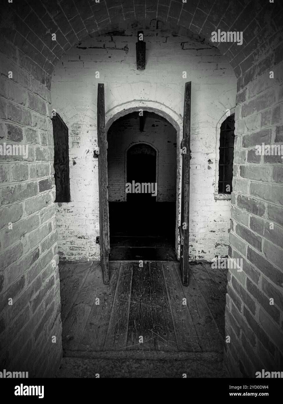 A dark and ominous open archway invites you into the unknown, perfect for a Halloween atmosphere - Smartphone Captured Stock Image