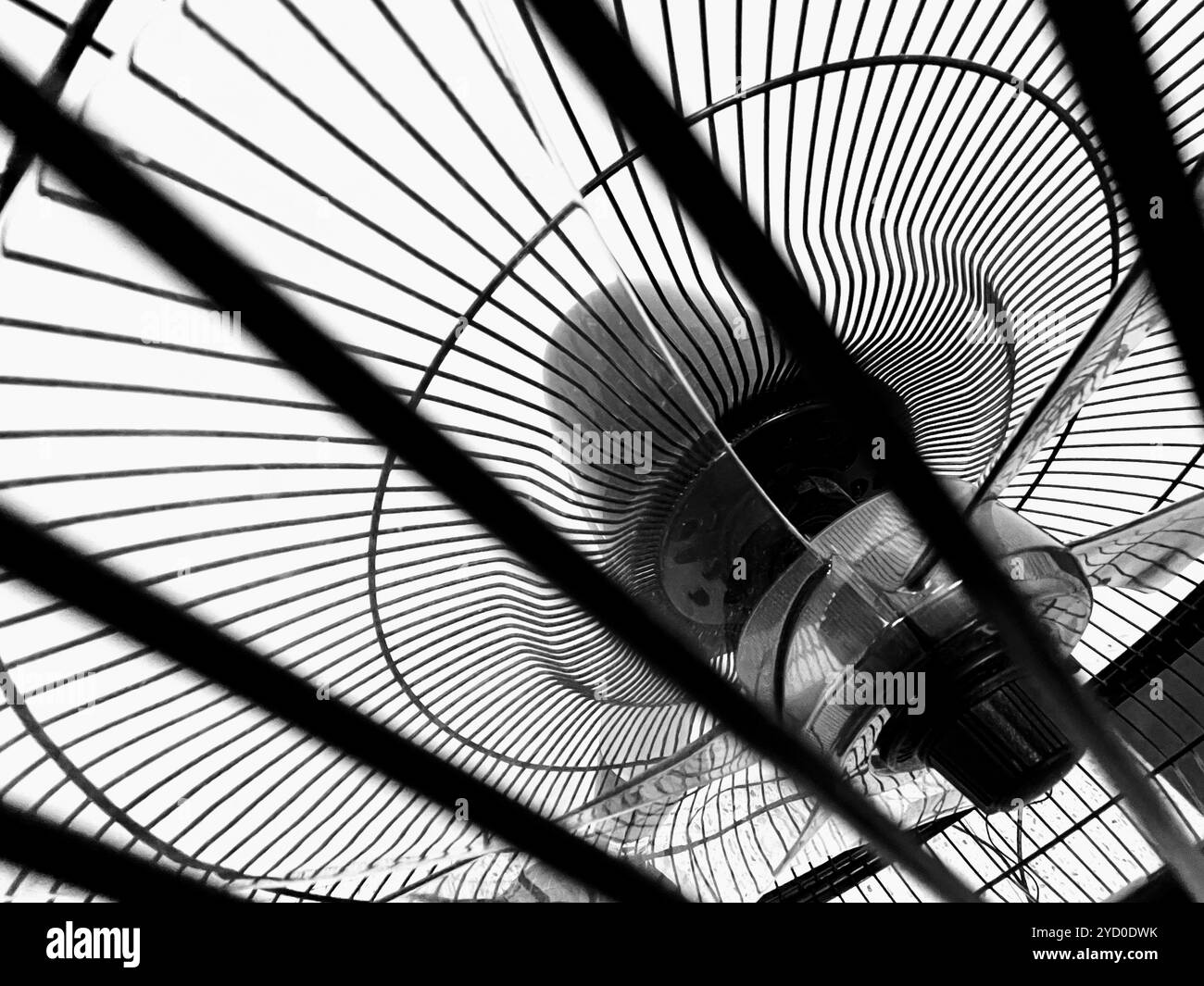 A monochrome close-up of a fan’s circular blades, creating a hypnotic and eerie pattern reminiscent of Halloween decorations - Smartphone Captured Stock Image