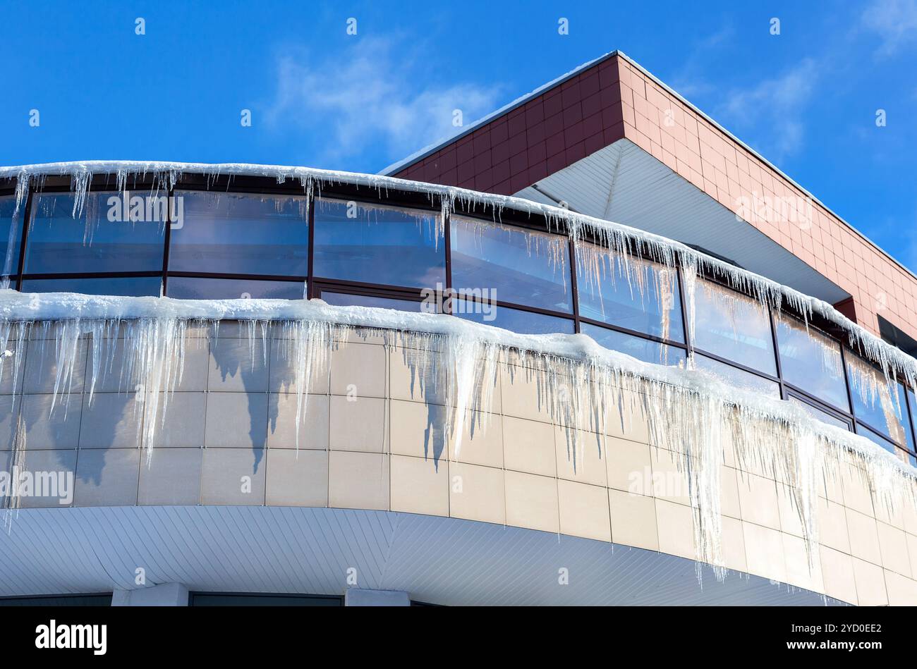 Transparent icicles on the roof of the house Stock Photo