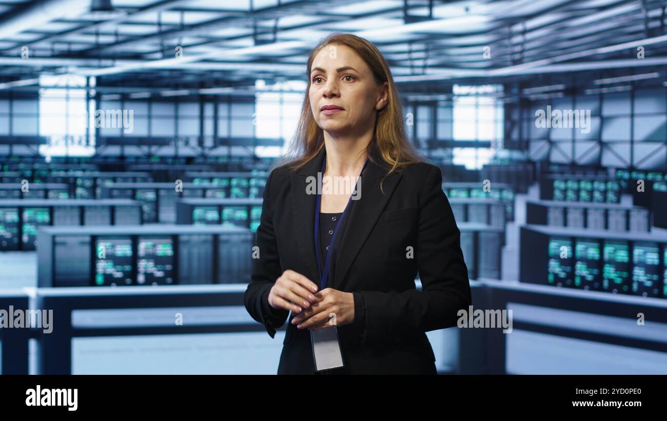 System administrator in high tech data center looking at hologram visualization. Computer scientist working on securing server terminals using AR tech, preventing hacker attacks, camera A Stock Photo