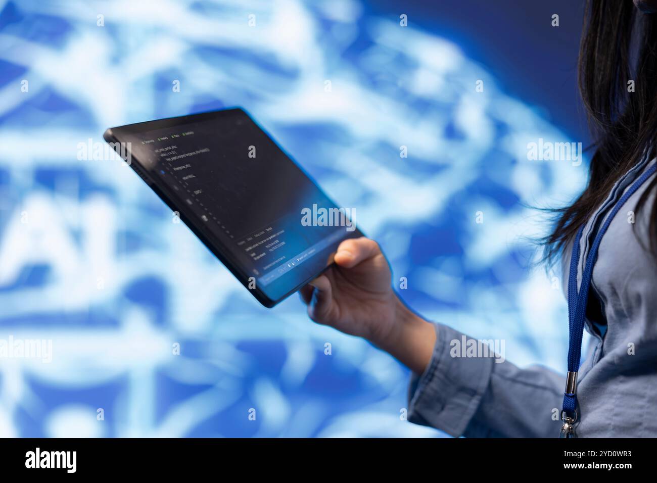 Software developer with tablet programming artificial intelligence computing simulating human brain. Close up of IT professional using device, building AI machine learning algorithms Stock Photo