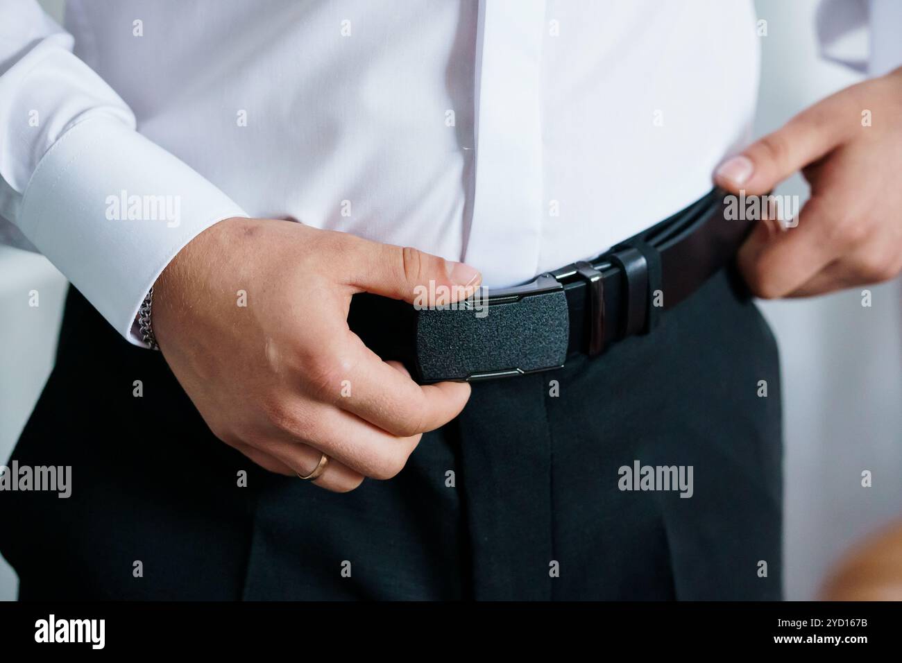 Elegant groom adjusting belt hi-res stock photography and images - Alamy