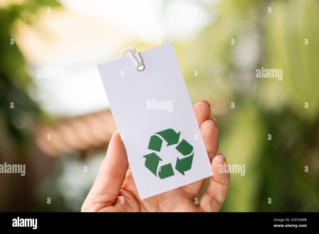 Hand holds a label with the words recycling icon. Recyclable product ...