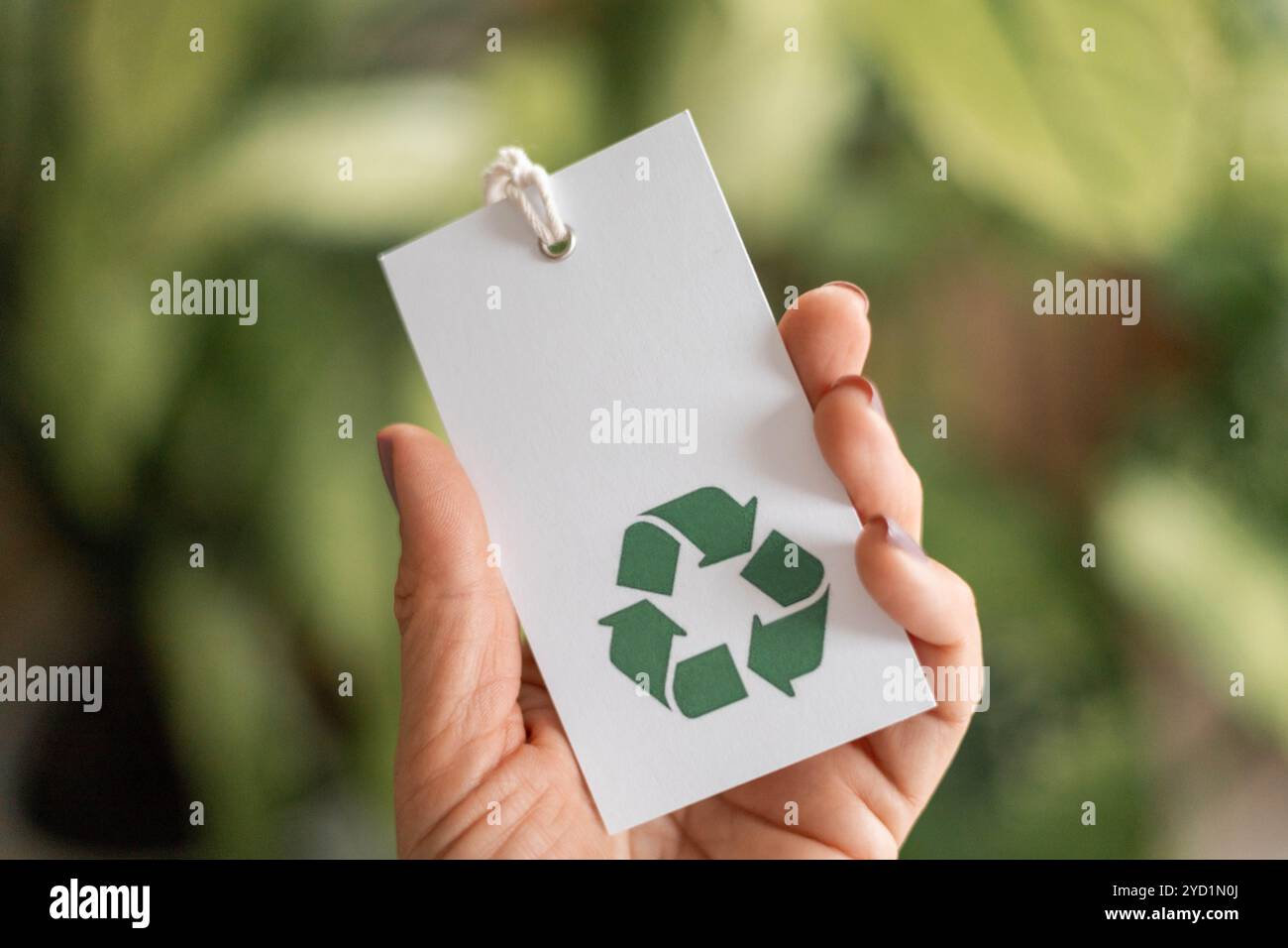 Hand takes a label with a recycling icon. Recyclable product concept ...