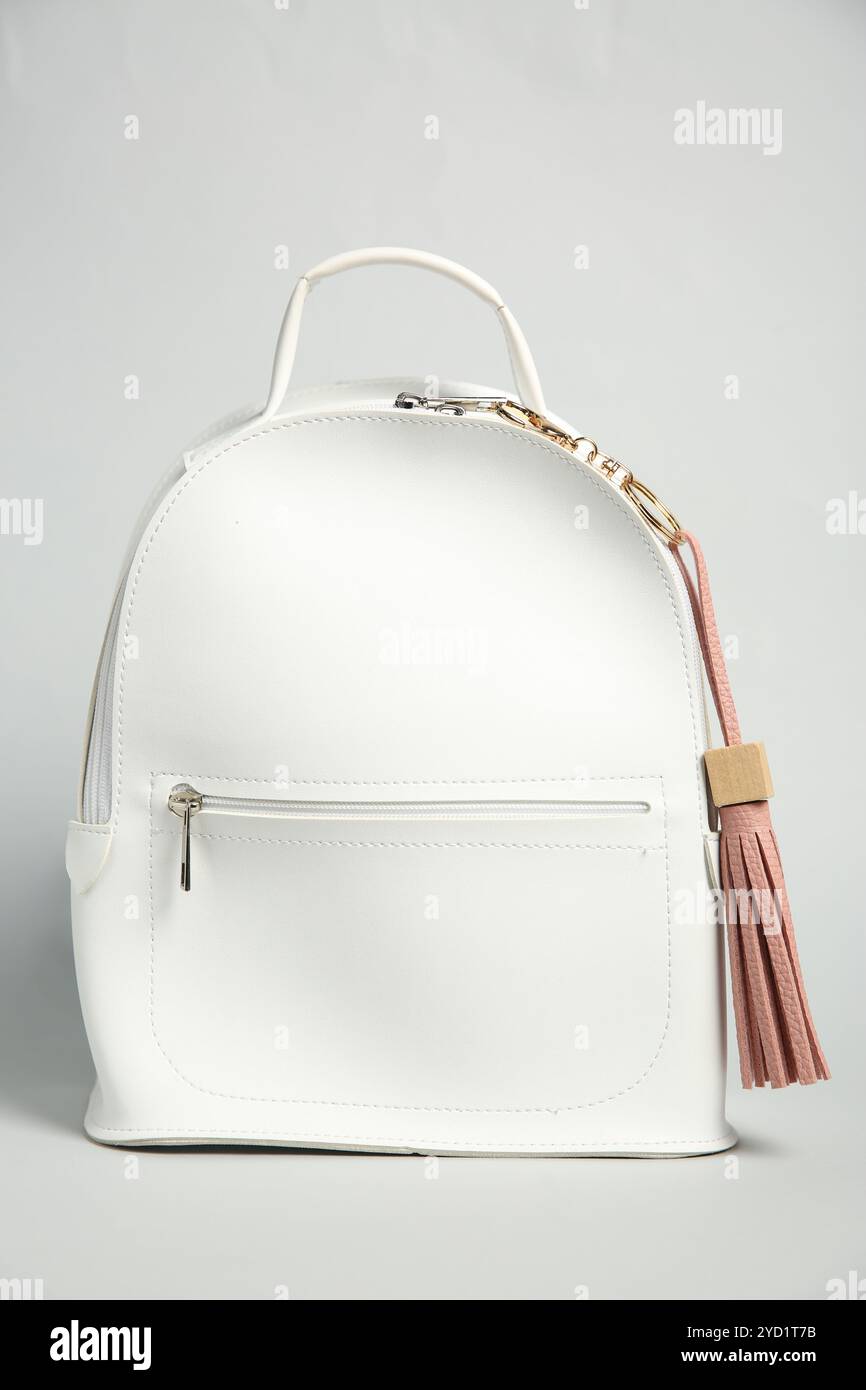 Backpack with pink leather keychain on grey background Stock Photo