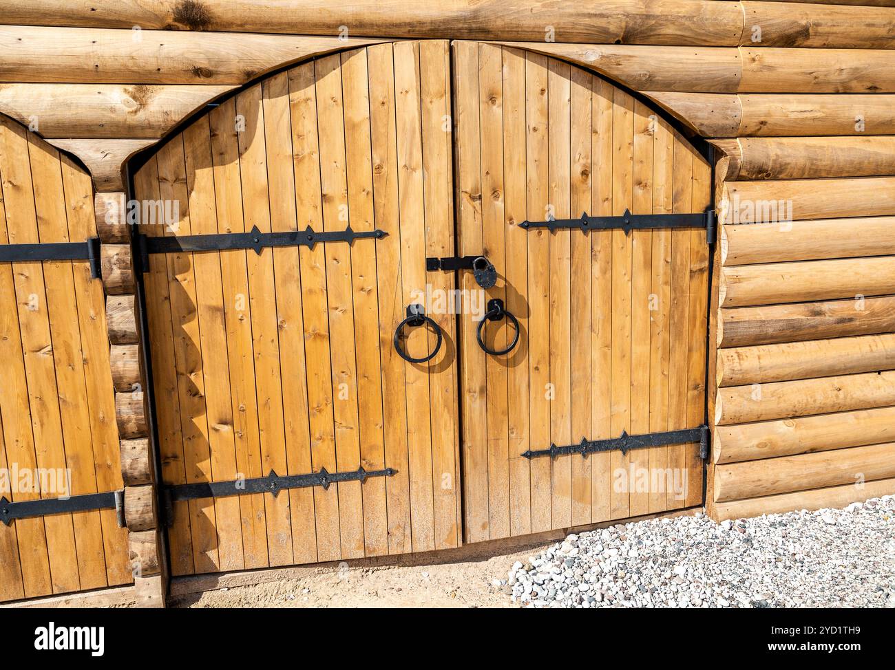 Massive wooden gate with forged metal hinges Stock Photo