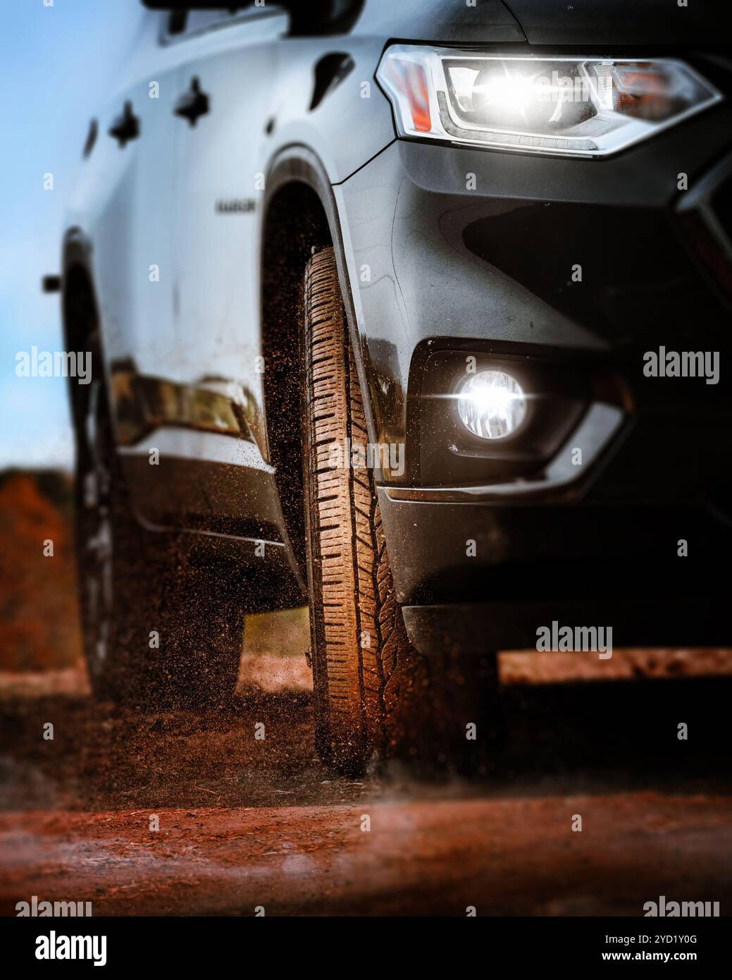SUV tires driving on muddy dirt road on countryside Stock Photo
