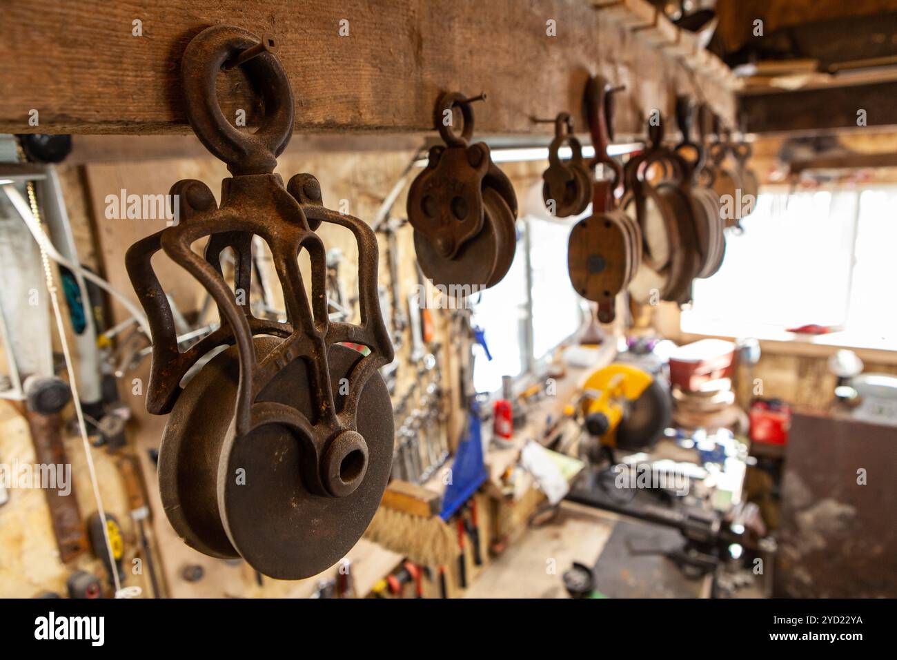 Rusty lifting wheels hanging in workshop Stock Photo - Alamy