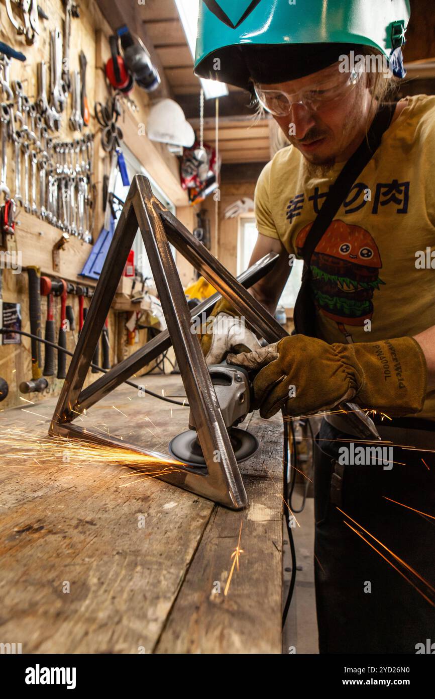 Blacksmith using angle grinder on project Stock Photo
