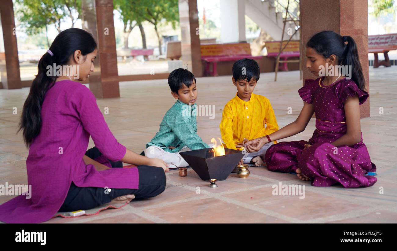 A Hindu family gathers around a sacred fire for Yagya during a festival ...