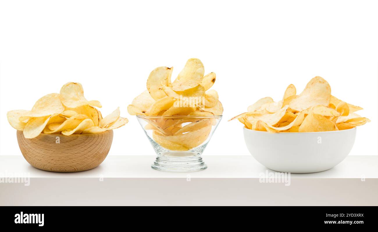 Potato chips into different bowls on white table. Stock Photo