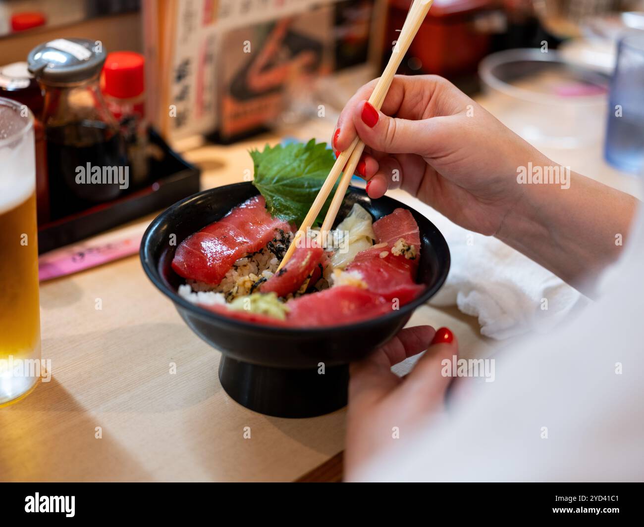 A lady eating Japanese food at a restaurant in Tokyo, Japan. Stock Photo