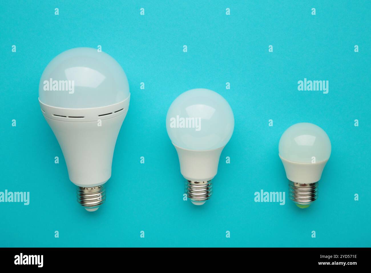 Comparison of different light bulbs on blue background. Top view Stock Photo