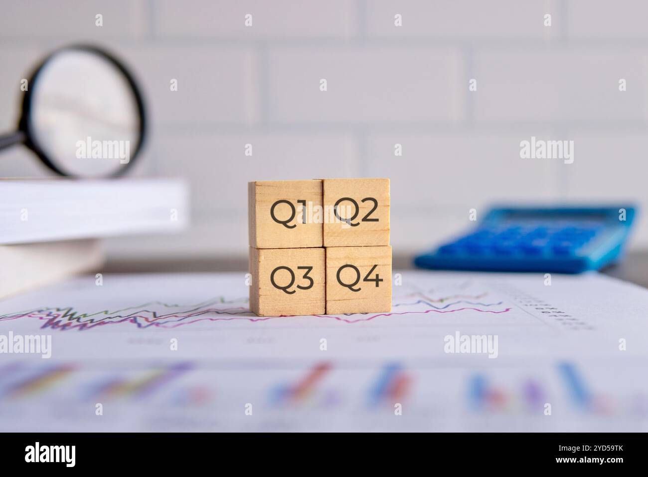 Wooden blocks placed on top of a graph paper representing a quarter of the year. Business concept. Stock Photo